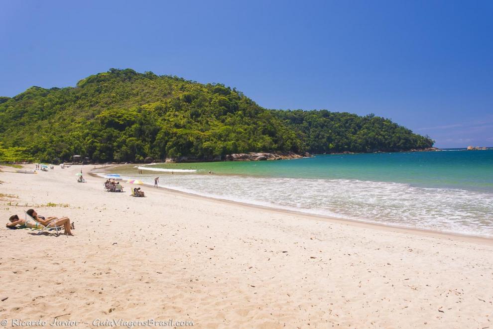 Imagem de alguns turistas nas areias da praia.